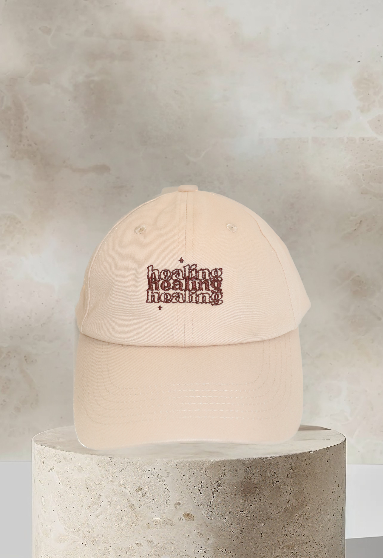 Tan dad hat with 'Healing' embroidered in brown cursive on front panel