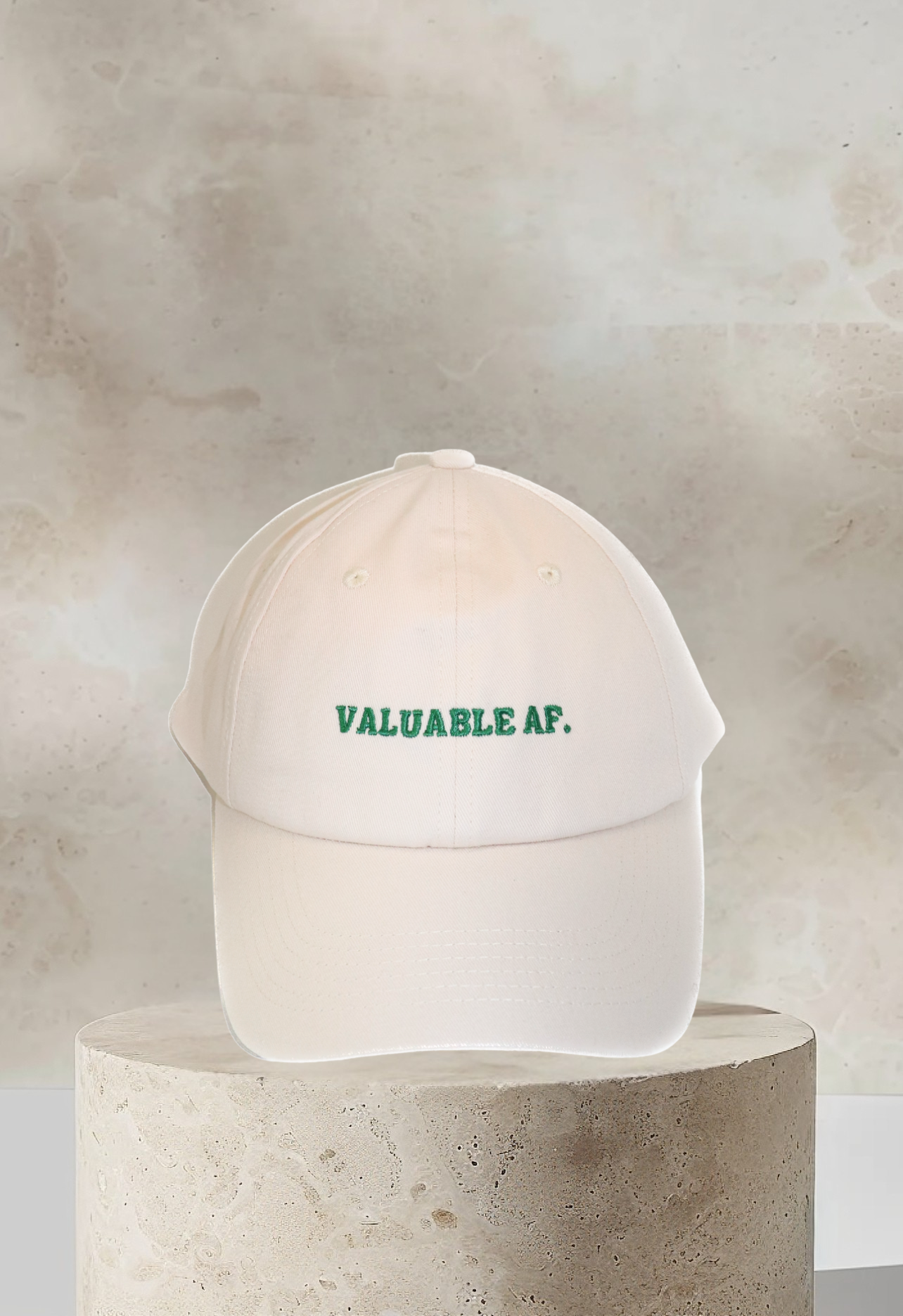 Cream dad hat with 'Valuable AF' embroidered in green on front panel